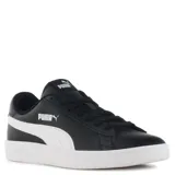 Championes urbanos Puma modelo Smash V2, color negro con la característica franja lateral en blanco. Presentan cierre con cordones, suela de goma blanca y logo de la marca en la lengüeta y el lateral.