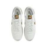 Championes Nike modelo Low Lux, color blanco con detalles en tono mostaza y suela blanca.