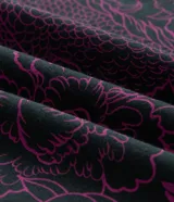 Remera de algodón color negro, con cuello redondo, mangas cortas y calce cómodo. Presenta una estampa frontal centrada con caracteres orientales en blanco sobre un diseño floral en tono fucsia.