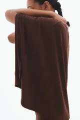 Vestido largo marrón de punto suave, con escote redondo, frunces en los laterales de la cintura y una sección delantera superpuesta con diseño de capa.