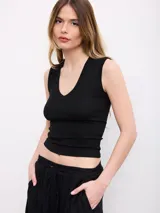 Top marrón de diseño ajustado al cuerpo, con escote en V pronunciado y sin mangas.