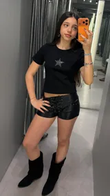Top negro de manga corta y corte ajustado, con detalle de estrella confeccionada en strass plateado en el centro del pecho.