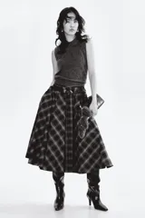 Chaleco de punto gris oscuro, sin mangas, con cuello camisero y tapeta de botones. Presenta un acabado de punto acanalado en las sisas y el bajo.