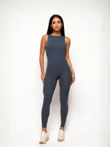 Jumpsuit deportivo de una pieza, color gris azulado, con cuello alto, sin mangas y diseño ajustado al cuerpo. Presenta un corte minimalista y sofisticado, ideal para entrenamientos o uso diario.