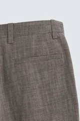 Pantalón de traje de corte slim fit, color marrón con textura sutil. Cuenta con cierre frontal de cremallera y botón, bolsillos laterales y bolsillos traseros de doble vivo con botón.
