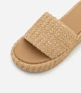 Sandalia flatform color beige con superficie trenzada, sin cierre, con tira ancha y puntera redonda.