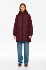 Abrigo largo de corte recto confeccionado en tejido técnico acolchado con diseño de rombos, cierre frontal con cremallera, cuello subido con capucha integrada, manga larga con puño elástico y bolsillos laterales.