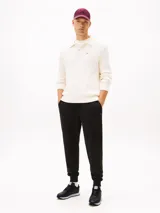 Zapatillas deportivas Tommy Hilfiger de estilo running, confeccionadas en una mezcla de piel y poliuretano. Presentan un diseño de corte bajo con cordones, paneles de texturas mixtas, detalles de ventilación en la parte superior y suela de goma con tacos.