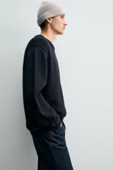 Jersey de punto con cuello redondo y manga larga, de corte regular fit con terminaciones en rib.