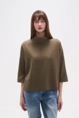 Polera de corte holgado en color verde oliva, con cuello alto y mangas tres cuartos.