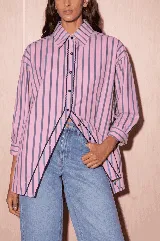 Camisa de popelina a rayas rosadas, marrones y azules, de corte holgado y relajado, con mangas largas y una distintiva abertura frontal con bordes ribeteados.