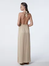 Vestido largo color marrón claro, con cuello halter y espalda descubierta.