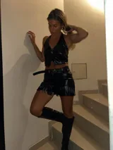 Short negro de cuero sintético con flecos.