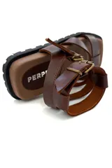 Sandalias de cuero marrón con tiras horizontales y ajuste con hebilla al tobillo.