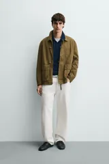 Parka de corte relajado confeccionada en mezcla de algodón color marrón. Presenta cuello solapa, cierre frontal con cremallera oculta y alamares metálicos, bolsillos de plastrón con solapa en la cadera y bolsillo de vivo en el pecho.