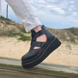 Zapatos de cuero con plataforma alta en tonos marrones y beige, diseño de tiras cruzadas en el empeine y laterales abiertos.