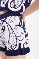 Short azul con estampado floral en beige, tejido en jacquard con elástico en la cintura y volado en el ruedo.