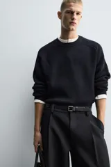 Jersey de punto con diseño boxy fit, cuello redondo y manga larga. Presenta una textura acanalada y acabados en rib en cuello, puños y ruedo.