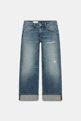 Jeans de mezclilla de tiro bajo y corte recto, con diseño de cinco bolsillos, trabillas para cinturón y dobladillo con vuelta ancha. Presenta un lavado azul medio con efecto desgastado.