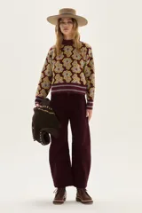 Sweater de cuello alto, color bordó, con diseño jacquard de flores en tonos gris y amarillo. Presenta puños y ruedo con terminación de rib de rayas horizontales en bordó, gris y amarillo.