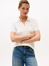 Chomba blanca de piqué de algodón orgánico elástico, corte slim, cuello polo y cartera de cuatro botones. Logo de Tommy Hilfiger bordado en el pecho.