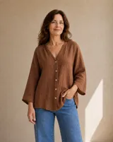 Camisa de lino color marrón tabaco, de corte holgado, con cuello en V, cierre frontal con botones y mangas tres cuartos anchas.