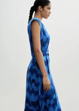 Vestido midi sin mangas con cuello redondo y diseño evasé. Confeccionado en tejido fluido de viscosa con estampado abstracto en tonos azules. Incluye cinturón ajustable con hebilla metálica en la cintura y cierre frontal de botones ocultos.