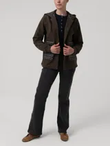 Buzo tipo campera de algodón orgánico color verde militar, con cierre frontal de botones a presión, capucha forrada con estampado étnico y bolsillos frontales con detalles de tejido aguayo multicolor.