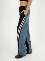 Pantalón de jean azul con corte jogger, cintura elastizada con cordón de ajuste y detalle de tres rayas blancas verticales en los laterales.