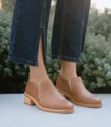 Zapato de cuero vacuno color tostado, con diseño de botineta baja, taco cuadrado de madera y detalle de perforaciones decorativas en el empeine.