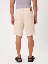 Bermuda color crudo de corte clásico, con bolsillos laterales y traseros, ideal para un look casual de verano.