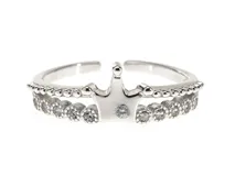Anillo de plata 925 con diseño de corona y detalles de circonias cúbicas brillantes, acompañado por una alianza fina decorada con pequeñas piedras incrustadas.