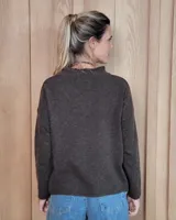 Sweater de tejido de punto color turquesa, con cuello en V y mangas largas de corte holgado.