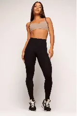 Top deportivo color beige con tirantes finos negros en contraste.