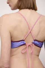 Conjunto de bikini compuesto por un corpiño triangular y una bombacha clásica, ambos en color bordó con ribetes en contraste en tonos rosado y mostaza.