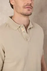 Chomba azul de piqué de algodón con cuello polo, tapeta de dos botones con diseño estampado en el interior y mangas cortas. Corte clásico.