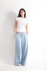 Pantalón jogger wide leg color celeste, con tiro medio, cintura elástica con cordón ajustable y bolsillos laterales.