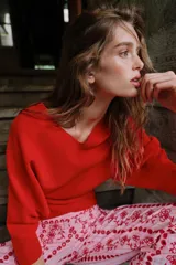 Jersey rojo de punto con escote en V pronunciado tanto en el delantero como en la espalda, mangas largas y diseño entallado en la cintura con caída acampanada.