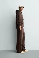 Sudadera con capucha de corte relajado, confeccionada en tejido de algodón con interior perchado. Presenta mangas largas, bolsillo frontal tipo canguro y terminaciones en rib.