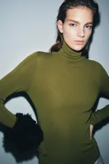 Jersey de cuello alto y manga larga, confeccionado en tejido de lana extrafina de textura suave y acabado liso.