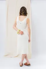 Vestido midi color crudo, de tejido acanalado, con escote en V y corte al cuerpo.