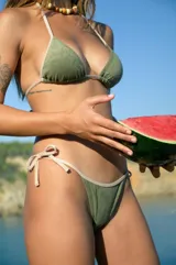 Conjunto de bikini verde militar confeccionado en tela de toalla. El corpiño es de triángulo con breteles ajustables en lycra nude y la bombacha es vedetina con breteles ajustables laterales en lycra nude.