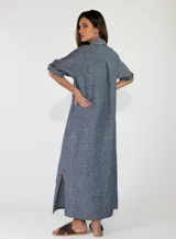 Vestido largo de lino color azul, con diseño estilo camisero, cuello camisero, cierre frontal con botones de madera y mangas largas con presilla para arremangar.