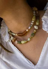 Gargantilla de cuentas artesanales multicolores, que incluye piedras facetadas, cuentas alargadas y un dije central de resina ámbar con forma angular.