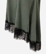 Remera verde militar de algodón con efecto desteñido, cuello redondo, mangas cortas, recortes asimétricos y detalle de encaje negro en el bajo irregular.