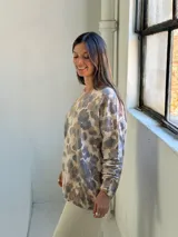 Sweater de punto con estampado animal print en tonos camel, gris y beige, de corte holgado, cuello redondo y mangas largas.