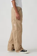 Pantalón de jean color beige, de corte recto y holgado, con bolsillos laterales y traseros.