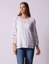 Blusa blanca con bordado calado tipo broderie, de mangas largas abullonadas.