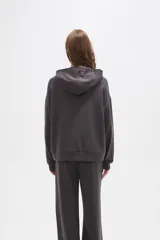 Canguro con capucha de calce holgado, color bordó, con detalle de aplique de strass en el pecho.