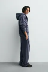 Sudadera de algodón con efecto lavado, color azul oscuro/gris pizarra, de corte 'boxy fit' y cierre frontal de cremallera. El interior de la capucha está forrado en tejido waffle de color gris claro. Posee bolsillos frontales de plastrón.